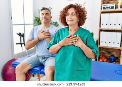 Physiotherapy Woman Working At Pain Recovery Clinic With Patient Smiling With Hands On Chest With Closed Eyes And Grateful Gesture On Face. Health Concept. 