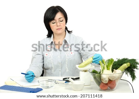 Phytocontrol technician weighing zucchini in quality control laboratory