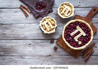 Pi Day Cherry and Apple Pies - making homemade traditional various Pies with Pi sign for March 14th holiday, on rustic wooden background, top view, copy space.