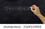 Pi number, mathematical constant chalk drawing on a school black board, Male hand write decimal digits with a chalk 

