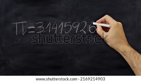 Pi number, mathematical constant chalk drawing on a school black board, Male hand write decimal digits with a chalk 

