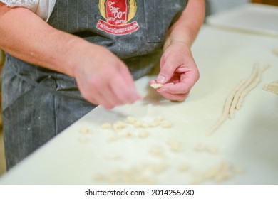 PIACENZA, ITALY - Jul 17, 2021: Woman Making Pisarei,  Tradtional Pasta , Extruded Fresh Pasta, Made Of Bread Crumbs, Water, Soft Wheat Four Type 00, Salt 