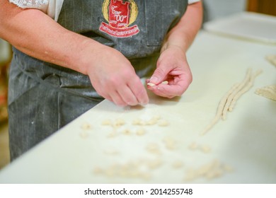 PIACENZA, ITALY - Jul 17, 2021: Woman Making Pisarei,  Tradtional Pasta , Extruded Fresh Pasta, Made Of Bread Crumbs, Water, Soft Wheat Four Type 00, Salt 