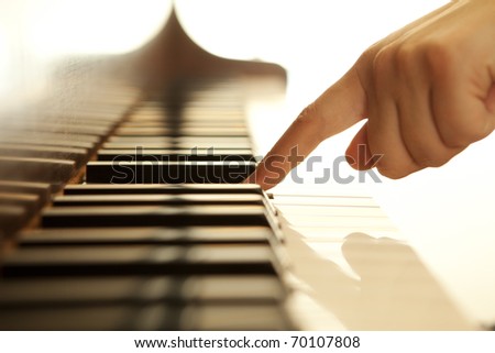 Pianist hand touching one of the piano keys.