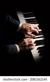 Pianist plays chord on piano with both hands. Touches gently the keyboard. White, male, mature hands. 