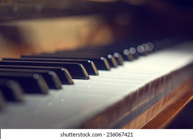 Piano keyboard background with selective focus. Warm color toned image