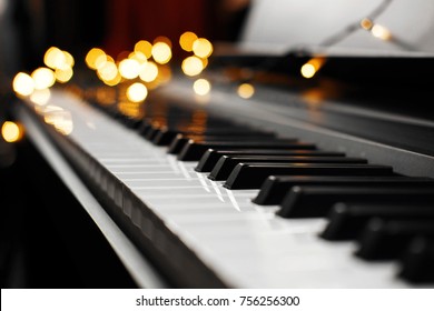 piano keys with beautiful yellow lights bokeh on background, piano keys with  Christmas lights, concert, backstage