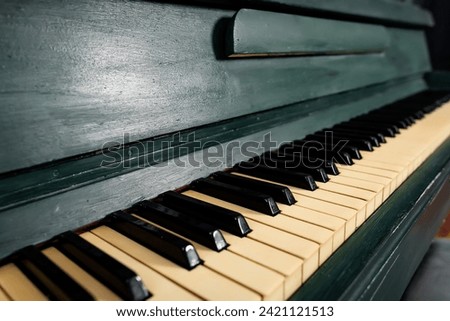 piano keys. black and white keys on a dark green piano. wooden musical instrument