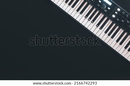 Piano keys, synthesizer on a black background, flat lay. [[stock_photo]] © 