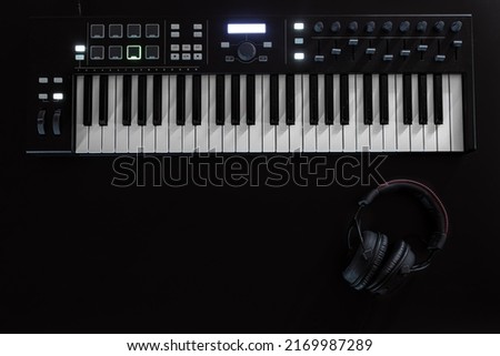 Piano keys, synthesizer on a black background, flat lay. [[stock_photo]] © 