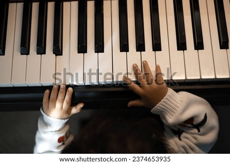 Piano learning - in this picture, a kid is learning to play piano or harmonium.