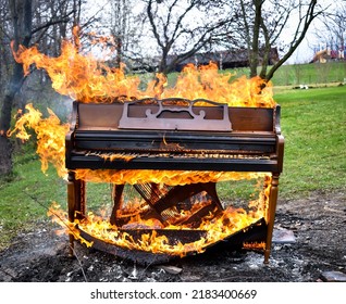 Piano on fire in a backyard.