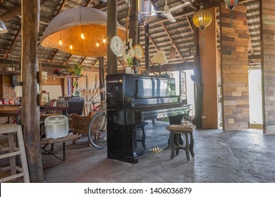 Piano and Props in Country Loft Interior Design Room. Interior design room include wood table and chair and lamp. Interior design room in part of living room