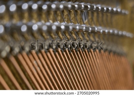 Piano strings pattern — harmony in copper and steel. Abstract close-up of piano strings and tuning pins forming a geometric pattern.