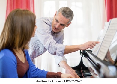 The Piano Teacher Gives Classes To A Young Woman