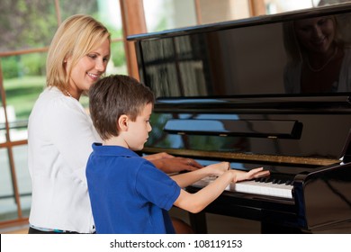 Piano teacher giving lessons to a young boy