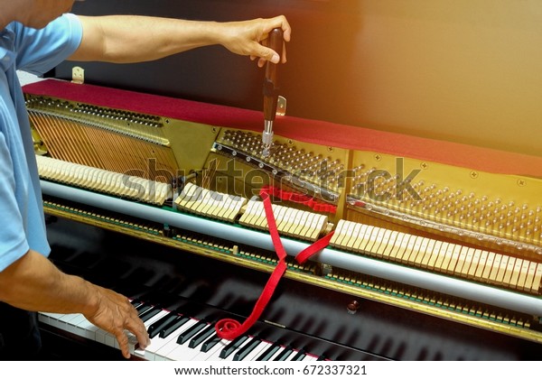Piano tuning , hand of piano\
tuner
