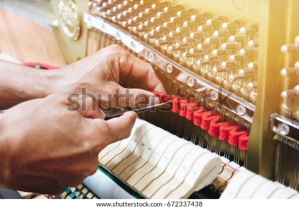 Piano tuning , hand of piano\
tuner