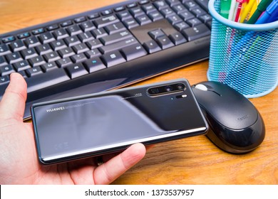 PIATRA NEAMT, ROMANIA - APRIL 13, 2019: Hand holds the new Huawei flagship, P30 Pro with office background. - Shutterstock ID 1373537957
