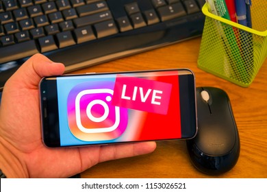 PIATRA NEAMT, ROMANIA - JULY 30, 2018: Hand Holds A Samsung S8+ With Instagram Live Logo  On The Screen, Office Background.