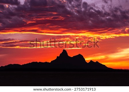 Picacho Peak at sunset. Located between Phoenix and Tucson, Arizona, the destination is known for its dramatic volcanic summit, steep hiking trails with cable assists, and spring wildflower blooms.