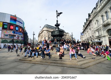 PICCADILLY CIRCUS London  June 06, 2014: People enjoying the sun at Piccadilly Circus London