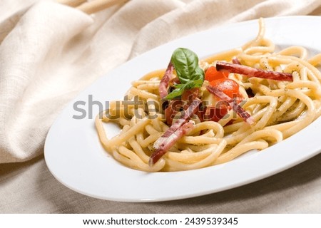 Pici senesi alla checca or Pici pasta from Siena Tuscany with mozzarella, basil, cherry tomatoes  and Tuscany lonza salami