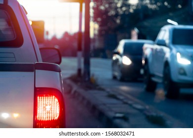 Pick up car on the road with light break at in evening. with other cars passing the traffic signal coming from the opposite side.