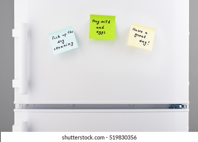 Pick Up The Dry Cleaning, Buy Milk And Eggs, Have A Great Day Notes On Blue, Green And Yellow Sticky Paper On White Refrigerator Door