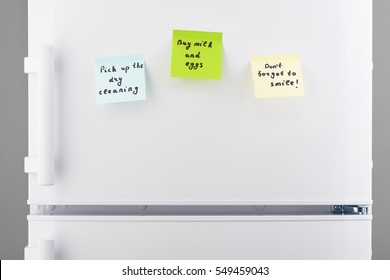 Pick Up The Dry Cleaning, Buy Milk And Eggs, Don't Forget To Smile Notes On Blue, Green And Yellow Sticky Paper On White Refrigerator Door