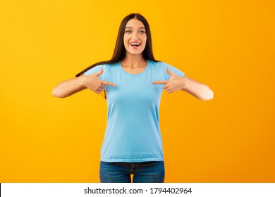 Pick Me. Positive female pointing at her self, wearing blank t-shirt for your text or promotional content