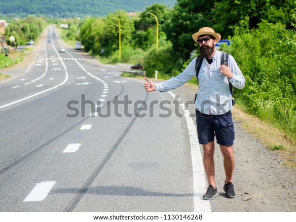Pick me up. Hitchhiking one of cheapest ways\
traveling. Picking up hitchhikers. Hitchhikers risk being picked up\
by someone who is unsafe driver or personally dangerous. Man try\
stop car thumb up.