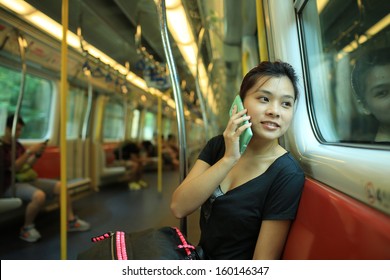 pick up the phone call go to the destination, talk on smart phone with good news, beautiful lady watch outside, in railroad box car MTR, hong kong,china, asia - Shutterstock ID 160146347