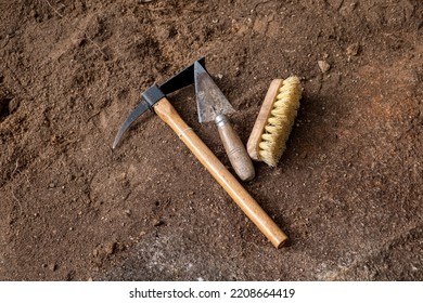 Pickaxe, trowel and brush. Tools in an archaeological excavation