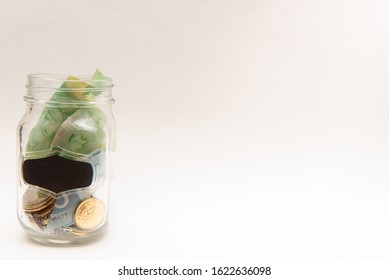  Pickering, Ontario/Canada - January 16 2020: Transparent Glass Jar With Money Inside On Top Of Wooden Table.  Concept For Swear Jar, Savings, Budgeting, Trip Fund.