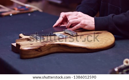 Pickguard being installed on electric guitar