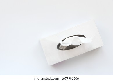 Picking facial napkin/tissue paper from the tissue box on white background. Top view. Flu, illness, pandemic concept
