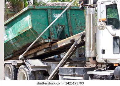 Picking Up Full Roll-off Dumpster At Residential  Construction Site For Efficient Disposal