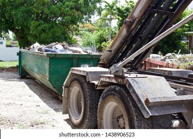 Picking Up Full Roll-off Dumpster At Residential  Construction Site For Efficient Disposal