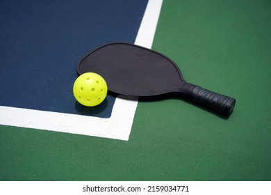 Pickle Ball Paddle With Pickle Ball On Court.                              