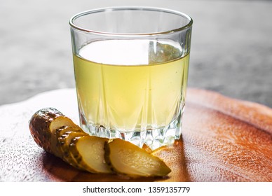 Pickle Juice Glass On Wooden Plate 