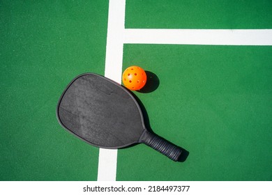 Pickleball Paddle And Pickle Ball On Court.                            