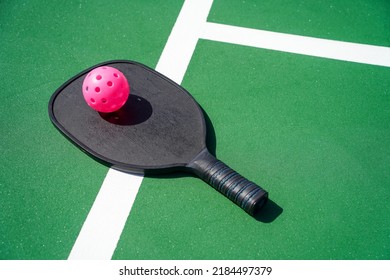 Pickleball Paddle And Pickle Ball On Court.                            