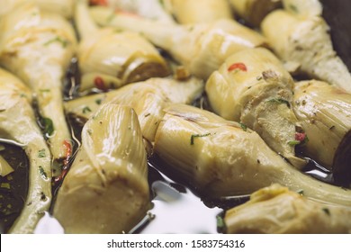 Pickled artichokes in oil and herbs. Classic italian appetizer for wine in italian cuisine. Vegetarian snack.