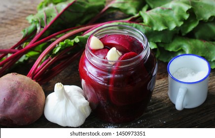 Pickled beets in the jar on a dark wood background .