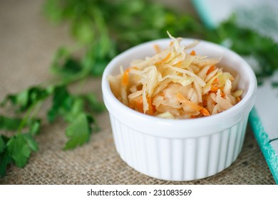 pickled cabbage and carrots in a white plate on the table