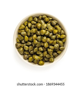 Pickled capers in a beige bowl isolated on white background. Marinated buds of caper bush. Mediterranean cuisine ingredient. Organic spices and seasonings for meat, fish and vegetables. Top view.