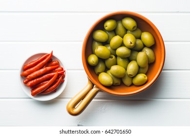 Pickled Chili Peppers And Green Olives In Bowl. Top View.