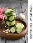 Pickled cucumber with dill and garlick in a rustic wooden bowl