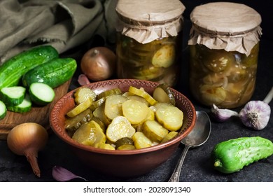 Pickled Cucumber Salad In A Bowl And Jars On Black Background